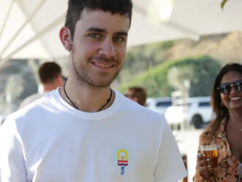 A photo of Alejandro with Sarika smiling behind him