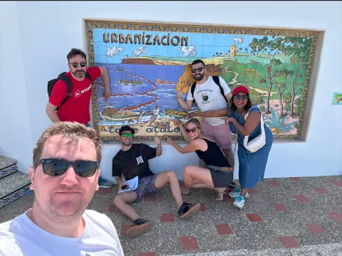 The "Dalia" team in front of a wall decorated with a tile painting
