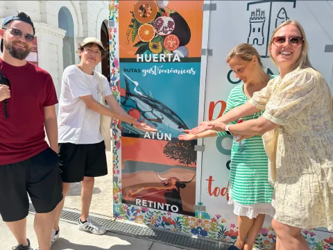 The “Geranio" team pointing to a tuna fish on a rollup sign