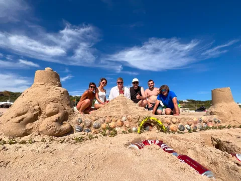 The “Hortensia” team posing behind a sandcastle decorated with shells