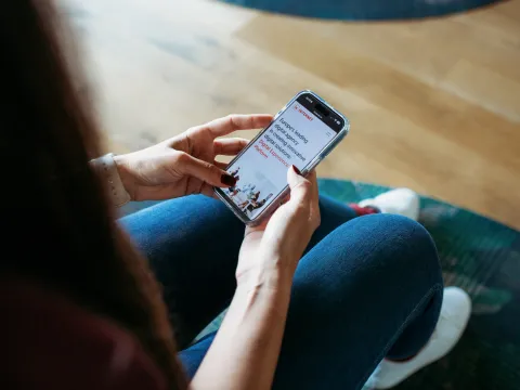 A girl sitting and checking her mobile phone