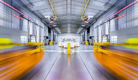 A spacious warehouse interior with yellow safety barriers
