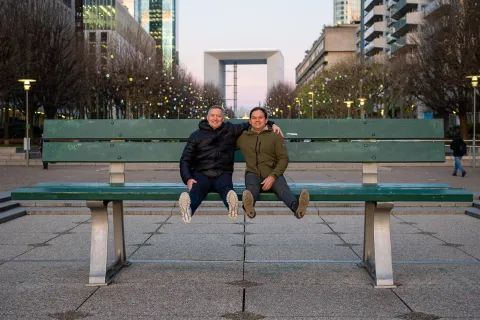 Artem and Christoph sitting on a giant bench in the center of Paris