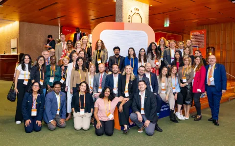 A diverse group of professionals posing together in a conference