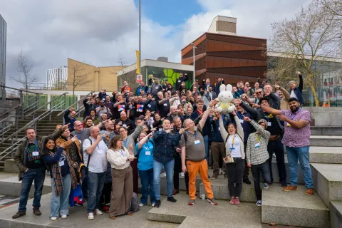Attendees of DrupalCamp England gather for a group photo outside the venue, Salford University