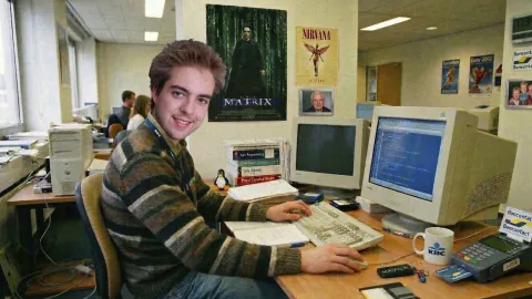 Young Dries Buytaert sitting at a desk in an office, using a computer