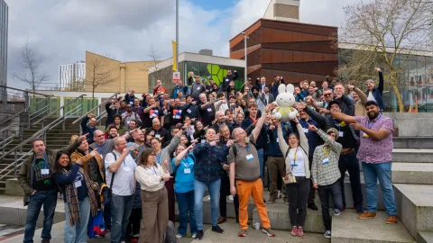 Attendees of DrupalCamp England gather for a group photo outside the venue, Salford University